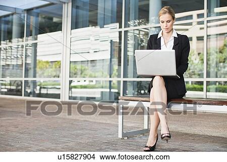 Picture - Businesswoman using laptop outdoors. Fotosearch