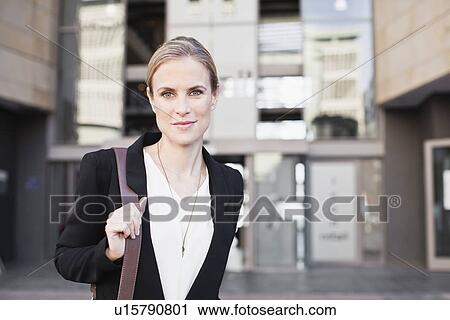 Stock Image - Businesswoman walking on city street. Fotosearch