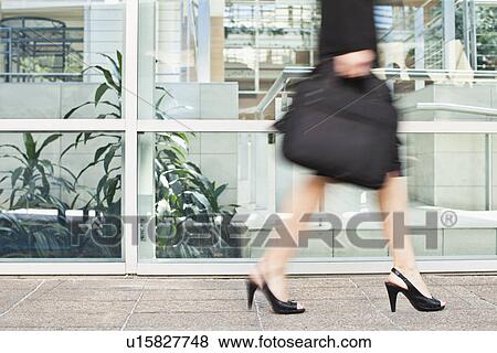 Stock Photo - Businesswoman walking on city street. Fotosearch