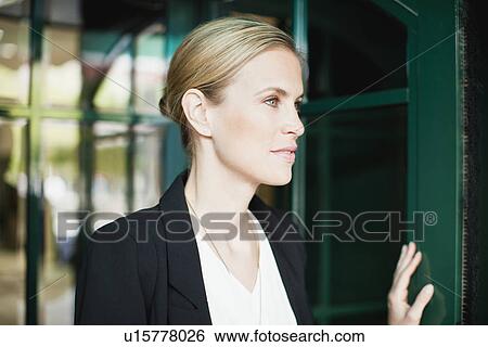 Stock Photograph - Businesswoman walking through doorway. Fotosearch