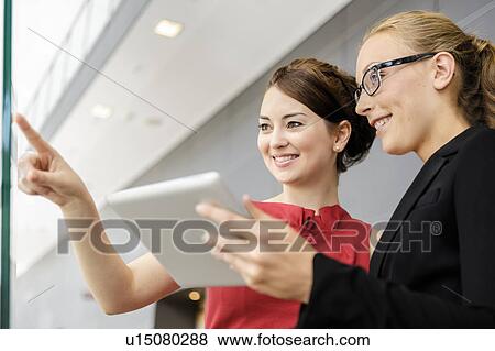 Businesswomen holding tablet computer View Large Photo Image Stock Photo - Businesswomen holding tablet computer. Fotosearch