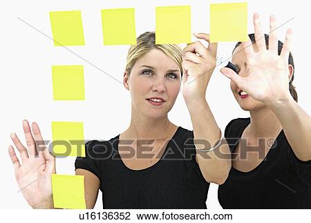 Businesswomen making sticky notes View Large Photo Image Stock Image - Businesswomen making sticky notes. Fotosearch