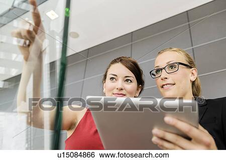 Businesswomen using tablet computer View Large Photo Image Stock Photograph - Businesswomen using tablet computer. Fotosearch
