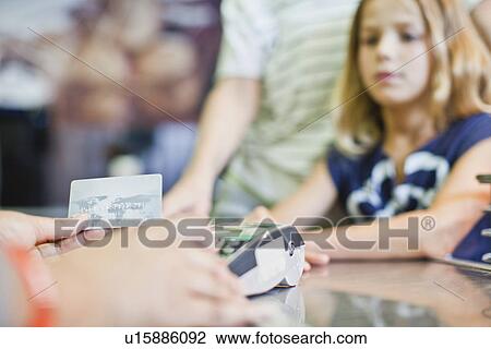 Cashier running credit card in store View Large Photo Image Stock Image - Cashier running credit card in store. Fotosearch