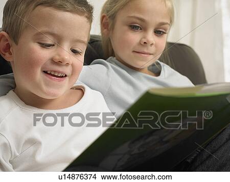 Children reading together on sofa View Large Photo Image Picture - Children reading together on sofa. Fotosearch