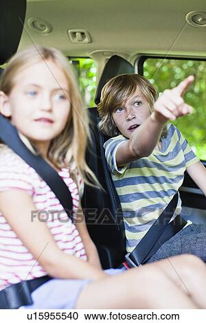 Stock Image - Children sitting in backseat of car. Fotosearch