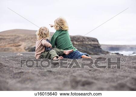Children sitting in sand on beach View Large Photo Image Stock Image - Children sitting in sand on beach. Fotosearch