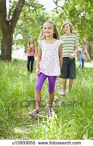 Stock Photography - Children walking together in grass. Fotosearch