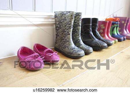 Stock Image - Childrens shoes lined up on floor. Fotosearch