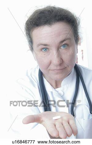 Stock Photo - Close up of doctor holding pill. Fotosearch