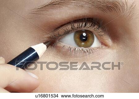 Picture - Close up of woman applying makeup. Fotosearch
