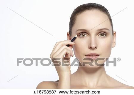 Stock Photo - Close up of woman applying makeup. Fotosearch
