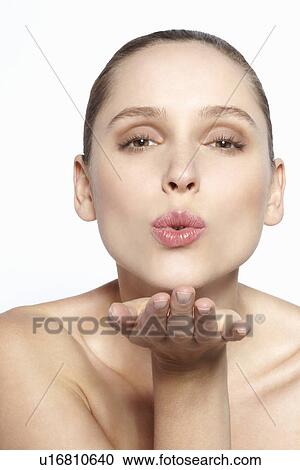 Stock Image - Close up of woman blowing a kiss. Fotosearch
