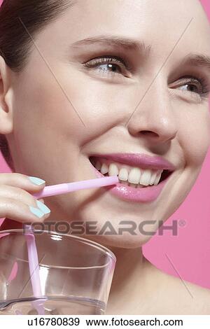 Stock Photo - Close up of woman drinking with straw. Fotosearch