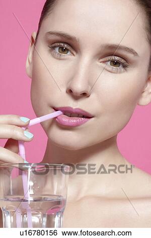 Stock Photograph - Close up of woman drinking with straw. Fotosearch
