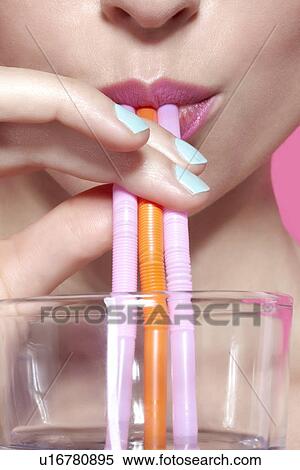 Stock Photography - Close up of woman drinking with straws. Fotosearch