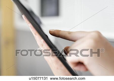 Stock Image - Close up of woman using tablet computer. Fotosearch