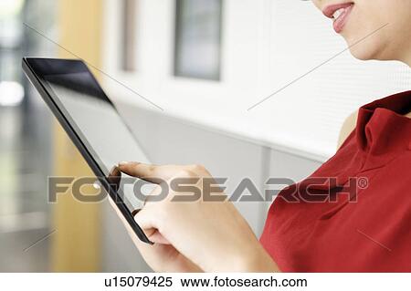 Stock Photography - Close up of woman using tablet computer. Fotosearch