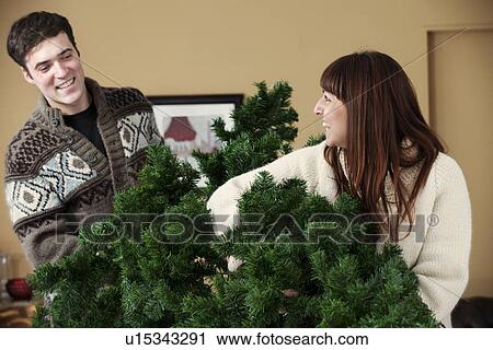 Couple carrying Christmas tree View Large Photo Image Stock Image - Couple carrying Christmas tree. Fotosearch