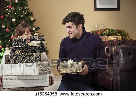 Stock Photo - Couple giving presents at Christmas. Fotosearch