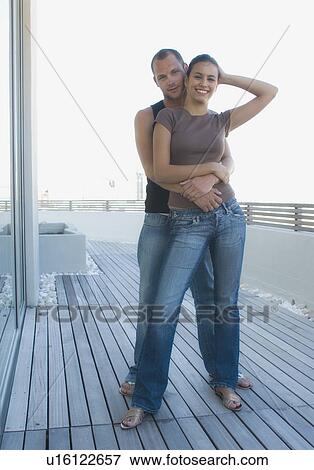 Stock Photo - Couple hugging on wooden deck. Fotosearch