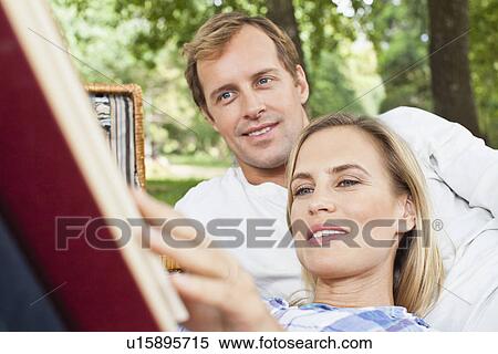 Stock Photography - Couple reading together in park. Fotosearch