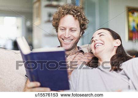 Couple reading together on sofa View Large Photo Image Stock Image - Couple reading together on sofa. Fotosearch