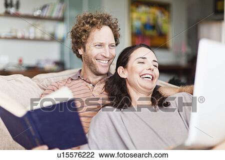 Couple reading together on sofa View Large Photo Image Stock Image - Couple reading together on sofa. Fotosearch