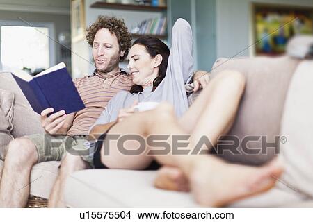 Couple relaxing together on sofa View Large Photo Image Picture - Couple relaxing together on sofa. Fotosearch