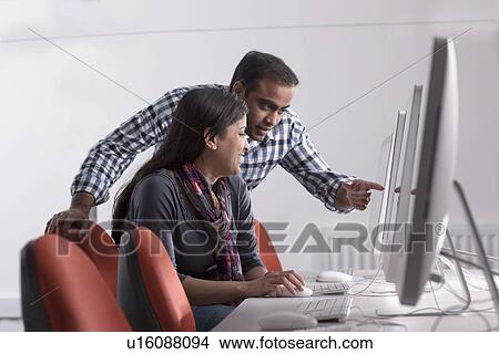 Couple using computer at desk View Large Photo Image Picture - Couple using computer at desk. Fotosearch