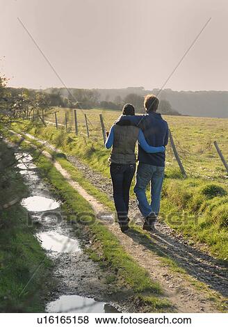 Couple walking on rural road View Large Photo Image Stock Photo - Couple walking on rural road. Fotosearch