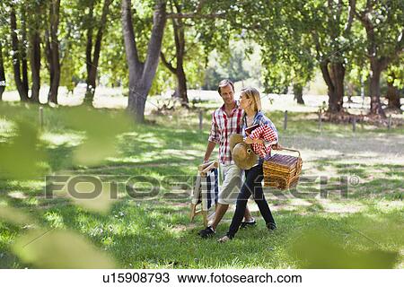 Couple with picnic basket in park View Large Photo Image Stock Image - Couple with picnic basket in park. Fotosearch