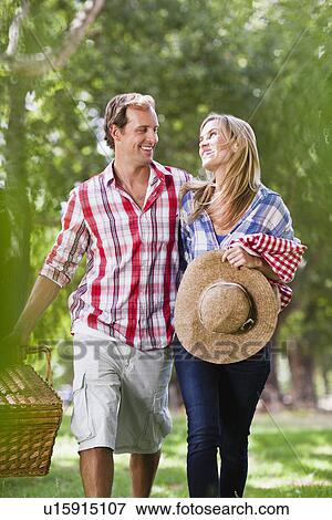 Couple with picnic basket in park View Large Photo Image Stock Photo - Couple with picnic basket in park. Fotosearch