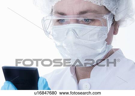 Doctor in face mask using tablet computer View Large Photo Image Stock Image - Doctor in face mask using tablet computer. Fotosearch