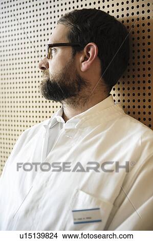 Picture - Doctor leaning against wall. Fotosearch