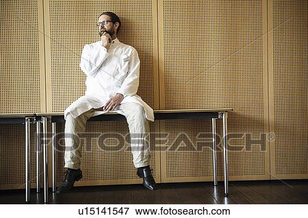 Stock Photo - Doctor sitting on table. Fotosearch