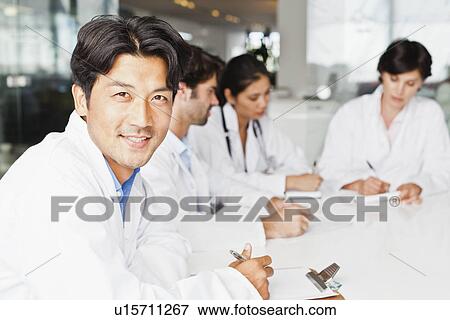 Stock Photo - Doctor smiling in meeting. Fotosearch