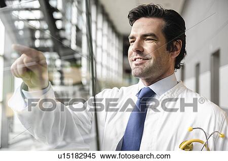 Doctor touching glass panel View Large Photo Image Stock Photography - Doctor touching glass panel. Fotosearch