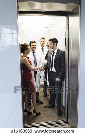 Stock Image - Doctors and business people in elevator. Fotosearch