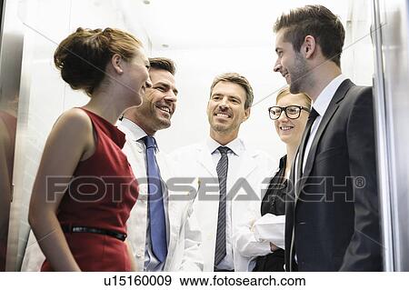 Doctors and business people in elevator View Large Photo Image Stock Photo - Doctors and business people in elevator. Fotosearch
