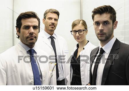 Stock Image - Doctors and businessman in elevator. Fotosearch
