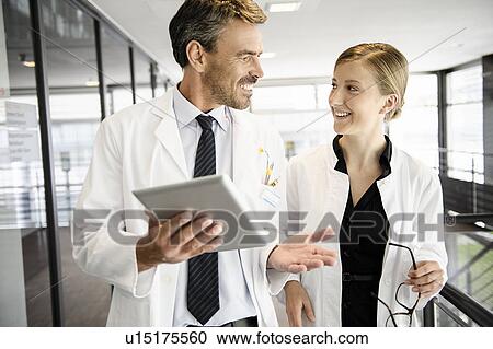 Stock Image - Doctors talking in hallway. Fotosearch