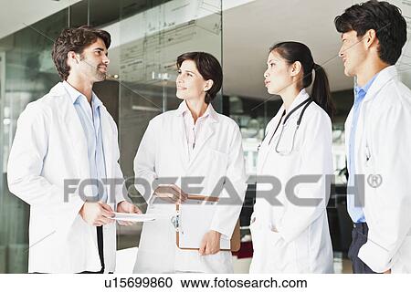 Stock Image - Doctors talking in hallway. Fotosearch