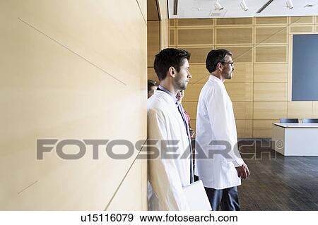 Doctors walking into conference View Large Photo Image Stock Photo - Doctors walking into conference. Fotosearch