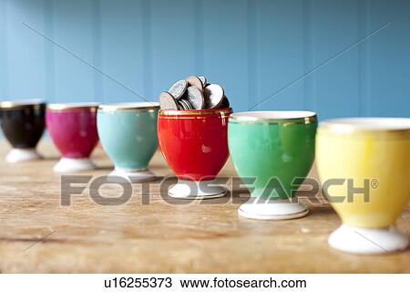 Egg cup full of money on desk View Large Photo Image Stock Image - Egg cup full of money on desk. Fotosearch