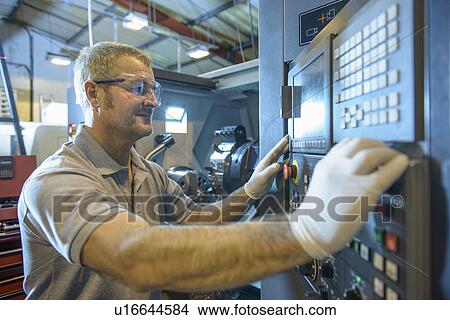 Picture - Engineer operating machinery in factory. Fotosearch