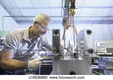 Engineer operating machinery in factory View Large Photo Image Stock Image - Engineer operating machinery in factory. Fotosearch