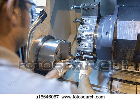 Stock Photo - Engineer operating machinery in factory. Fotosearch
