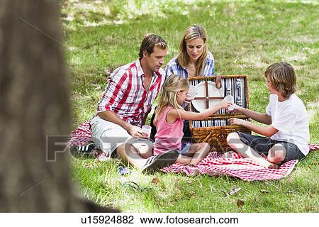 Stock Image - Family having picnic in park. Fotosearch