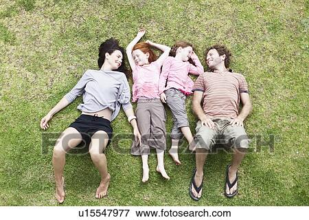 Family laying in grass together View Large Photo Image Stock Photo - Family laying in grass together. Fotosearch